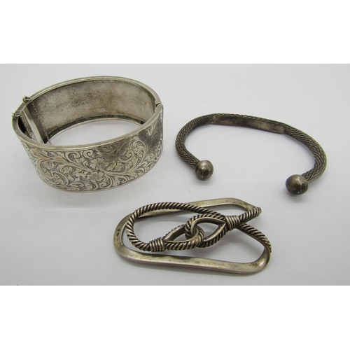 351 - Small group of silver comprising a Hermes rope design money clip, a hinged bangle with engraved scro... 