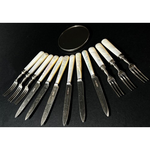 205A - A Harrods mother of pearl set of silver fruit knives and forks and a small silver pocket mirror.