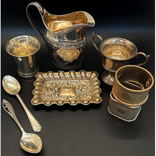 211 - A mixed selection of silver including a cream jug, two napkin rings, a beaker, dish, a twin handled ... 