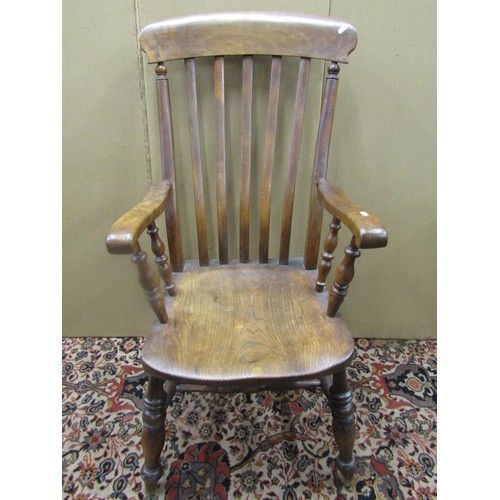 A Victorian Windsor lathe back elbow chair in elm and beechwood, on turned supports