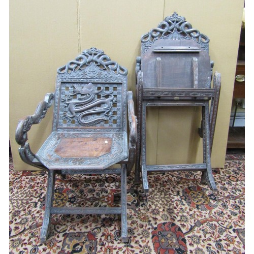 1468 - A pair of 19th century Chinese folding armchairs, profusely carved and detailed with dragons, serpen... 