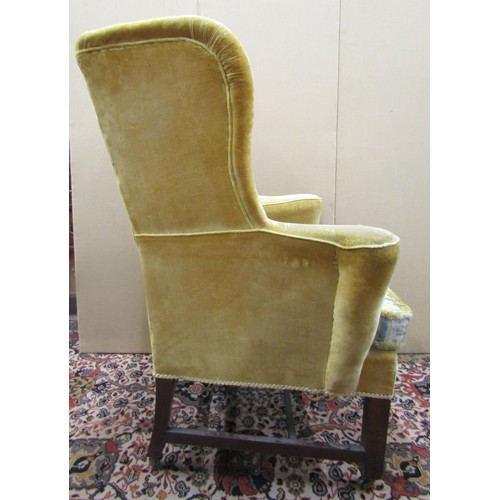 1473 - A 19th century mahogany wing chair with swept arms, raised on square cut supports with H shaped stre... 