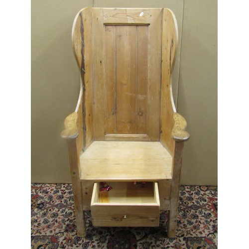 1477 - A Georgian pine lambing chair with stripped and waxed finish, the panelled back within a winged fram... 