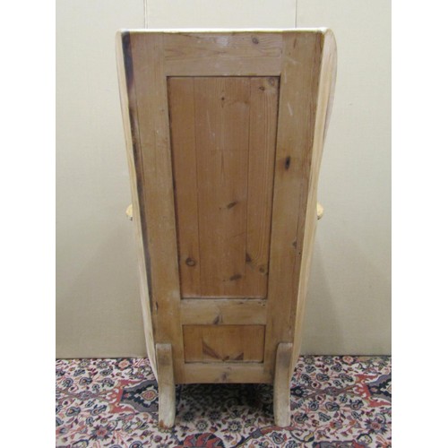 1477 - A Georgian pine lambing chair with stripped and waxed finish, the panelled back within a winged fram... 