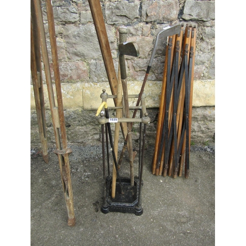 1035 - A vintage cast iron and brass four divisional umbrella/stick stand containing various canes and two ... 
