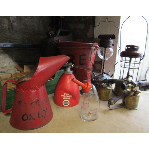 1052 - Two vintage fire buckets, box of carpenter's planes, Tilley paraffin lamps, blow lamps, garage oil c... 