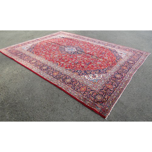 1514 - A Persian Kashan carpet with rich red ground and traditional floral medallion, 393cm x 300cm