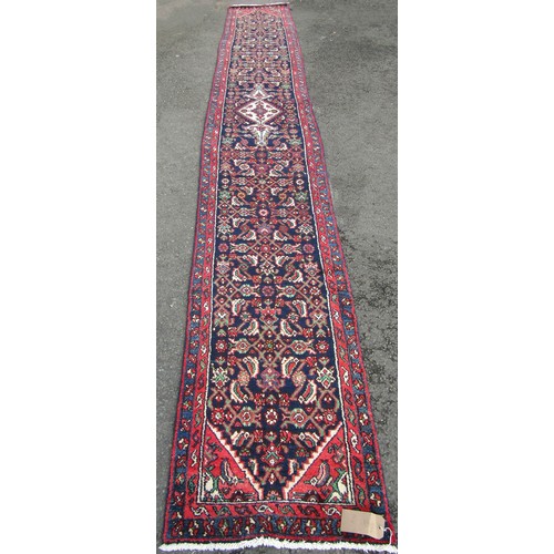 1518 - A Persian Sarouk runner full pile with rich red and blue pattern, 500cm x 66cm