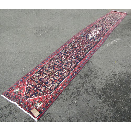 1518 - A Persian Sarouk runner full pile with rich red and blue pattern, 500cm x 66cm