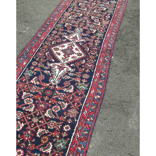 1518 - A Persian Sarouk runner full pile with rich red and blue pattern, 500cm x 66cm