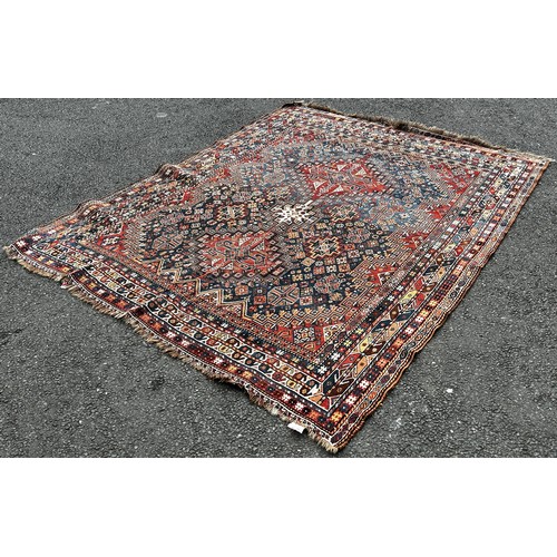 1495 - An old Persian Heriz carpet with an all over stylised flower and geometric pattern 246cm x 200cm