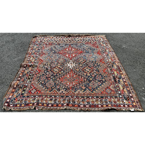 1495 - An old Persian Heriz carpet with an all over stylised flower and geometric pattern 246cm x 200cm