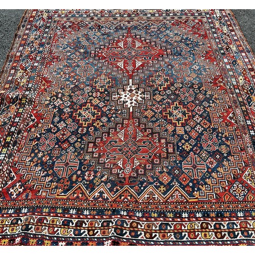 1495 - An old Persian Heriz carpet with an all over stylised flower and geometric pattern 246cm x 200cm