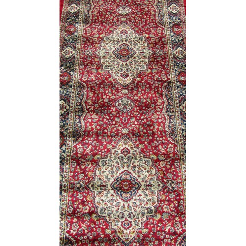 1520 - A Kashmir runner with a full pile red ground, 300cm x 80cm