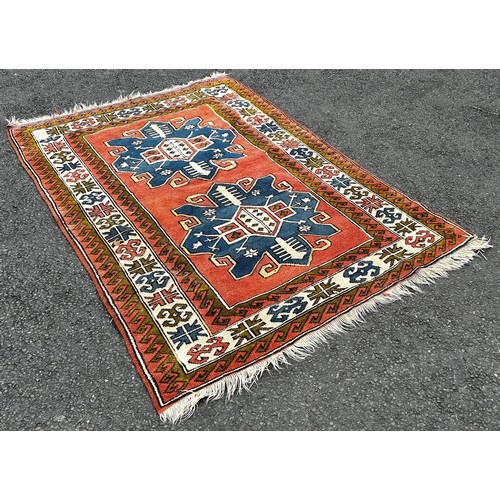 1505 - A Kazak Carpet with two large blue stepped lozenge on a pink ground, 210cm x 145cm