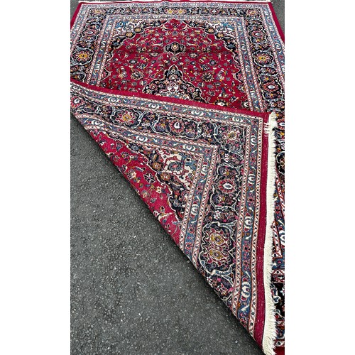 1509 - A Kasahan Persian carpet with a central blue medallion in a red surround of flowers, 310cm x 200cm.