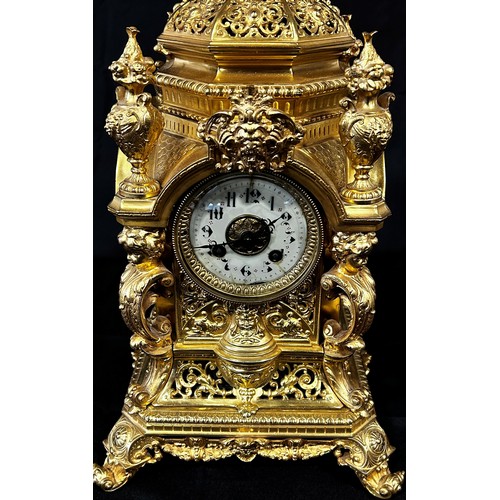 446 - A 19th century gilt brass mantle clock, the casework with pierced and scrolled detail, surmounted wi... 