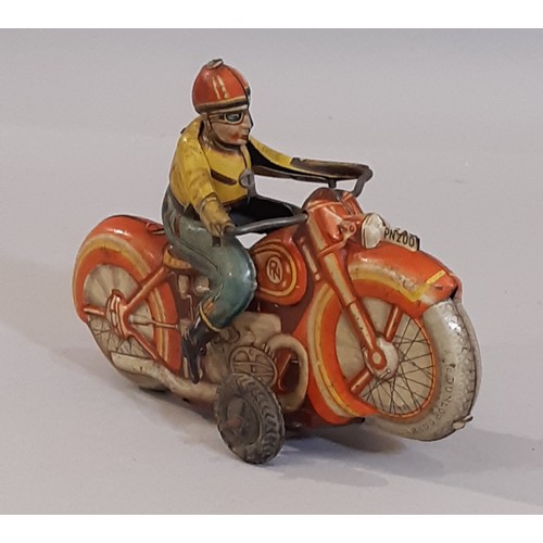 818 - A vintage clockwork  tin plate motorcycle and rider, made in West Germany. Length 16cm