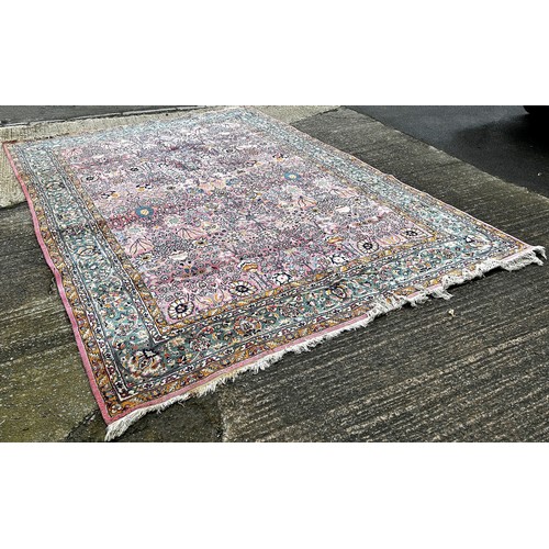 1529A - A large Persian design carpet with an all over floral pattern on a pink ground, 350cm x 250cm.