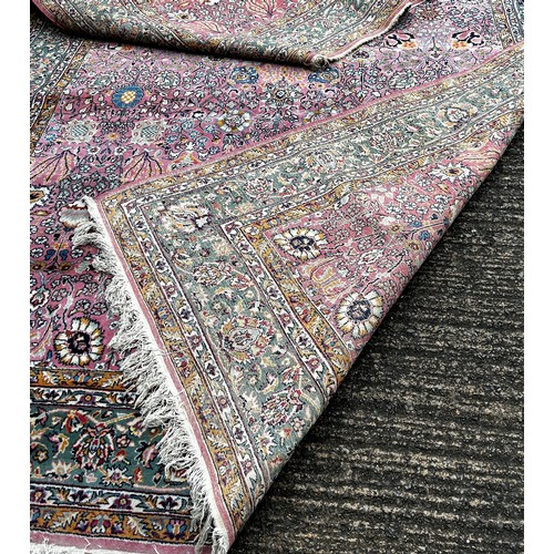 1529A - A large Persian design carpet with an all over floral pattern on a pink ground, 350cm x 250cm.