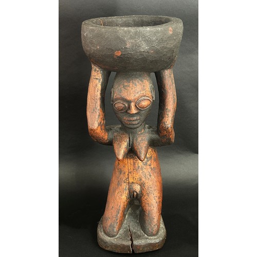 1741 - An old African carved hardwood figural tazza / vessel, in the form of a nude figure kneeling, holdin... 