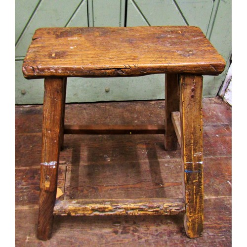 1476 - A rustic elm stool, the rectangular top raised on splayed supports, 50cm high