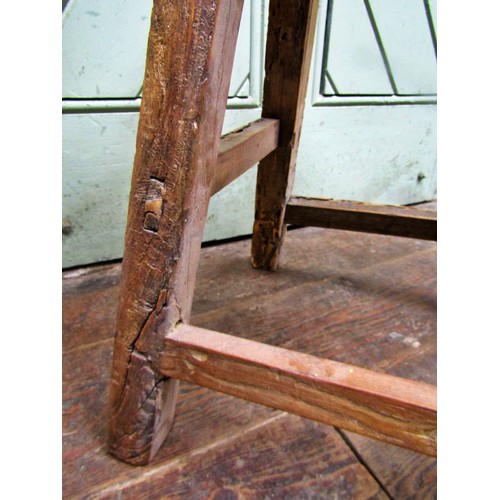 1476 - A rustic elm stool, the rectangular top raised on splayed supports, 50cm high