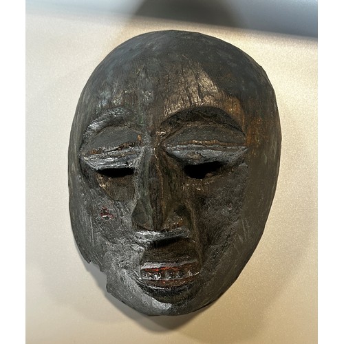 1739 - A small carved African hardwood mask, believed to be early 20th century or earlier, with remnants of... 