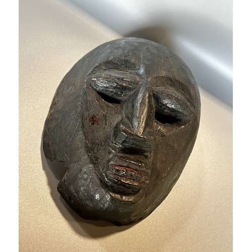 1739 - A small carved African hardwood mask, believed to be early 20th century or earlier, with remnants of... 