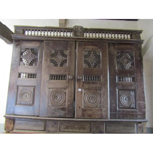 1029 - A substantial antique Breton two sectional side cupboard, the upper enclosed by a pair of sliding do... 