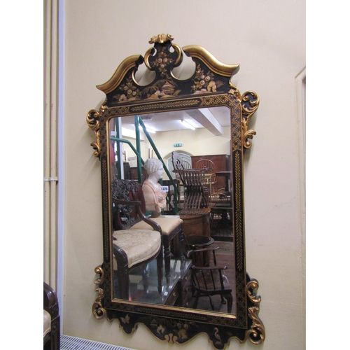 1370 - An 18th century style wall mirror with chinoiserie detail frame in black and gilt, set beneath a mou... 