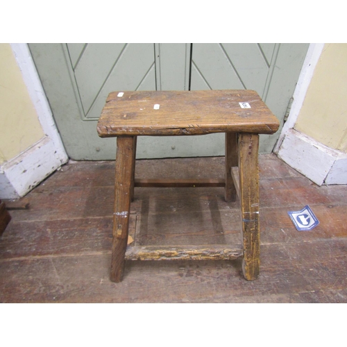 1476 - A rustic elm stool, the rectangular top raised on splayed supports, 50cm high