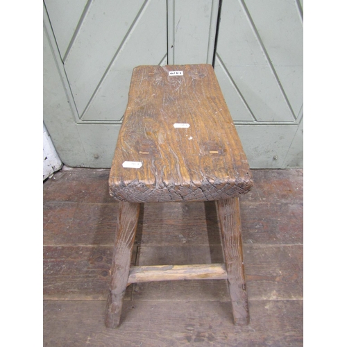 1476 - A rustic elm stool, the rectangular top raised on splayed supports, 50cm high