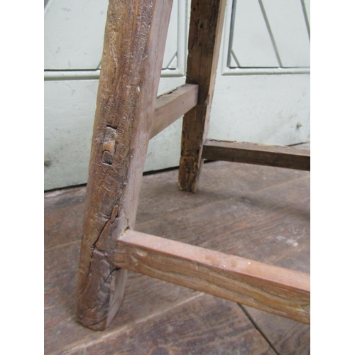 1476 - A rustic elm stool, the rectangular top raised on splayed supports, 50cm high