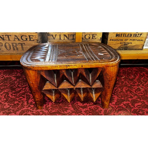 1736 - A central African carved hardwood stool of rounded, rectangular form, the chip-carved top decoration... 