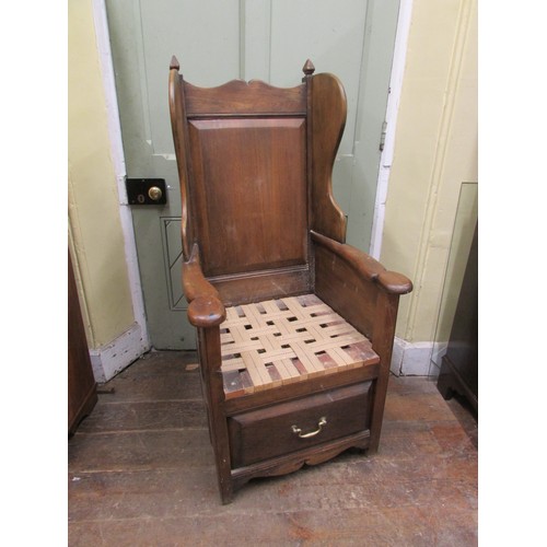 1482 - An old English style oak lambing type chair with winged and fielded panelled back over a drawer base