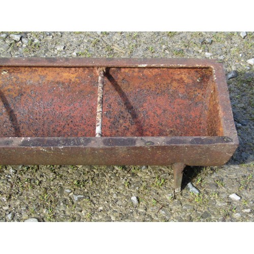 77 - An old cast iron rectangular pig trough with five simple rung divisions, 181cm long x 32cm wide x 17... 