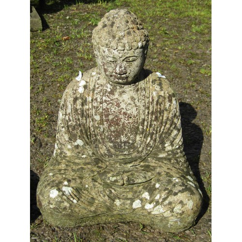 78 - A cast composition stone garden ornament in the form of a seated Buddha in lotus position, raised on... 