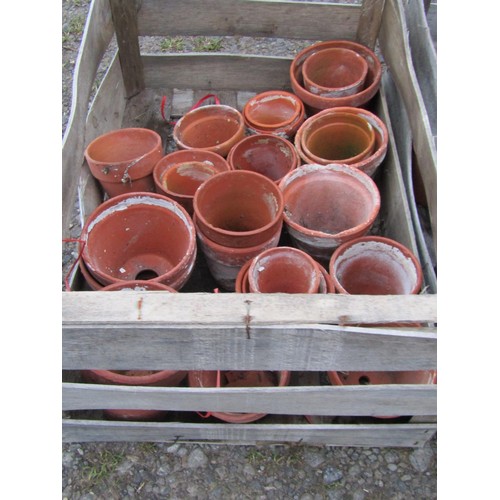 83 - Three weathered wooden crates containing a quantity of terracotta flower pots of varying size and de... 