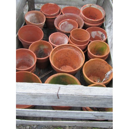 83 - Three weathered wooden crates containing a quantity of terracotta flower pots of varying size and de... 