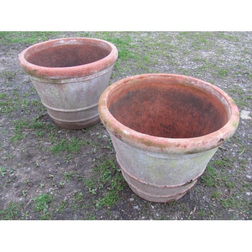 65 - A pair of large weathered terracotta planters of circular tapered and simple ribbed form, 56 cm high... 