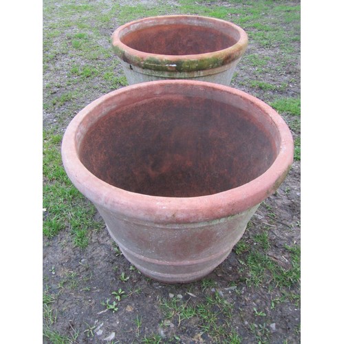 65 - A pair of large weathered terracotta planters of circular tapered and simple ribbed form, 56 cm high... 