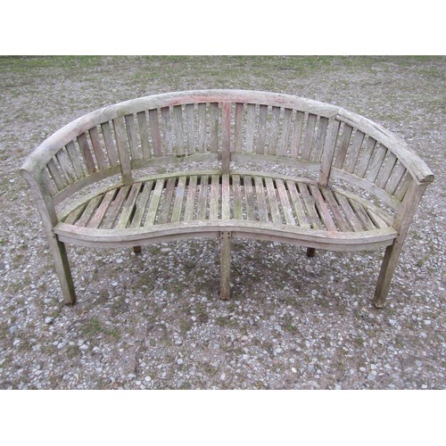 88 - A weathered teak banana shaped garden bench, 156cm wide  (af)