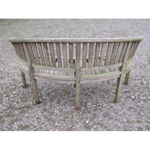 88 - A weathered teak banana shaped garden bench, 156cm wide  (af)