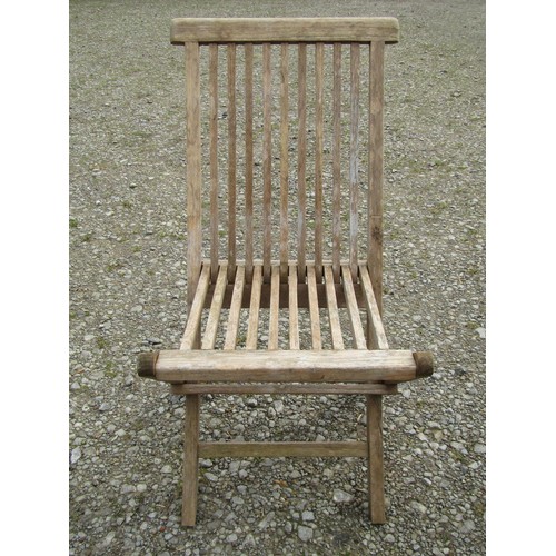 91 - A small weathered teak garden table with circular slatted top, raised on square cut supports, 100cm ... 