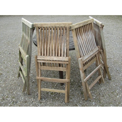 91 - A small weathered teak garden table with circular slatted top, raised on square cut supports, 100cm ... 