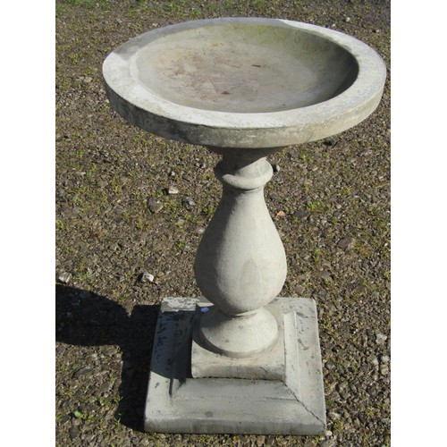 92 - A cast composition stone three sectional bird bath of circular form raised on a baluster pedestal an... 