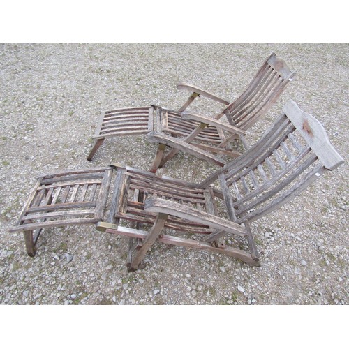 98 - Two weathered teak folding steamer type chairs with slatted seats, backs and foot rests, with brass ... 