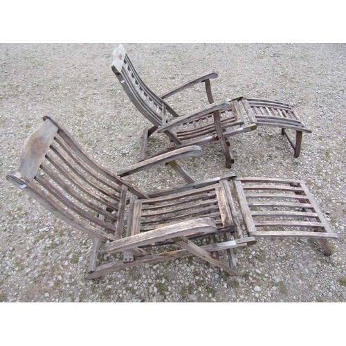 98 - Two weathered teak folding steamer type chairs with slatted seats, backs and foot rests, with brass ... 