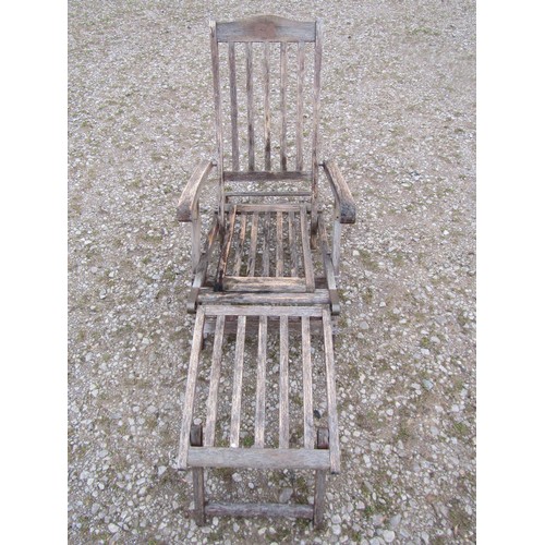 98 - Two weathered teak folding steamer type chairs with slatted seats, backs and foot rests, with brass ... 